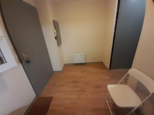 an empty hallway with a chair and a door at Sweet Lodge in Échirolles