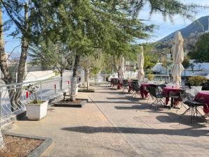a patio with tables and chairs and umbrellas at Hotel corner in Bërzhitë