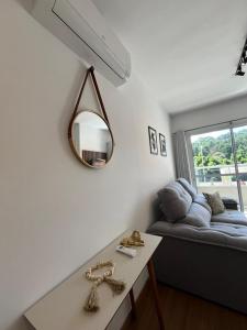 a living room with a couch and a mirror at Mel Prime Loft – executive apartment in Extrema, MG in Extrema