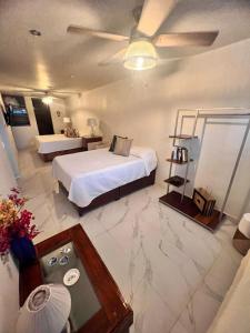 a hotel room with two beds and a table at Hosteleria Casa Margarita in Mazatlán +64 photos