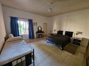 a bedroom with two beds and a desk and a window at El Ñangapiri in Mercedes
