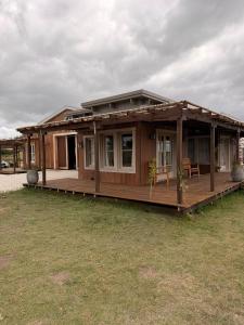 a wooden house with a porch on a grass field at eastwood in San Carlos
