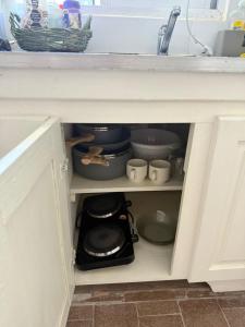 a cabinet filled with pots and pans in a kitchen at Merlo mar 2 in Merlo