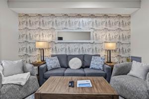 a living room with a couch and a tv at Mystic Springs #108 - Hot Tub and Pool, Pets managed by Little Sister Getaways in Canmore