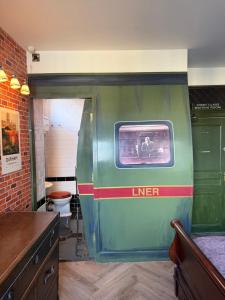 a green train car in a room with a toilet at Durham Central Suites in Gilesgate