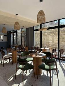 a restaurant with tables and chairs and windows at Hotel and Coffee Bar Old Bazaar in Skopje
