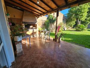 a patio with a table and a wooden roof at El Ñangapiri in Mercedes