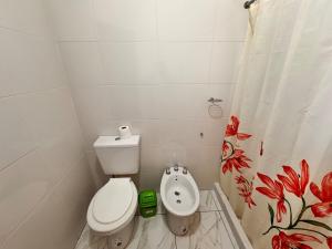 a bathroom with a toilet and a shower curtain at casa villa azul 1 in Tanti +18 photos