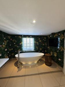 a large bath tub in a bathroom with floral wallpaper at Durham Central Suites in Gilesgate +134 photos