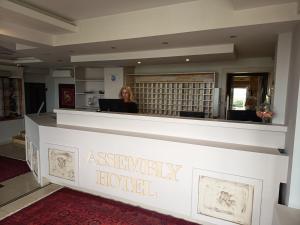 Eine Frau sitzt an einem Rezeptionsschalter in einem Agenturhotel in der Unterkunft SKG Assembly Β&Β Hotel in Thessaloniki + 42 Fotos