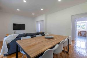 a living room with a wooden table and a couch at Carcavelos Village III By Staycalm in Carcavelos