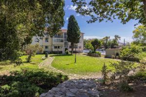 a park in front of a building with a tree at Carcavelos Village III By Staycalm in Carcavelos