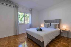 a bedroom with a bed with a teddy bear on it at Carcavelos Village III By Staycalm in Carcavelos