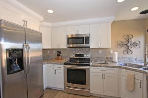a kitchen with stainless steel appliances and white cabinets at Balcony-Views-Country Club Living-VV667 in Palm Desert