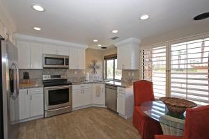 a kitchen with white cabinets and a table in it at Balcony-Views-Country Club Living-VV667 in Palm Desert