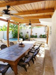 an outdoor dining room with a wooden table and chairs at Jobos Beach House - Steps from the beach! in Isabela