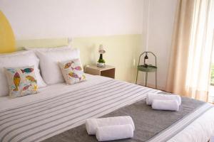 a bedroom with a large bed with two pillows at Kalimera Aegina in Agia Marina Aegina