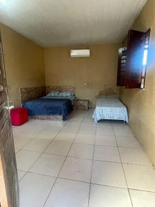 a room with two beds and a tiled floor at Sítio Resenha in Caucaia