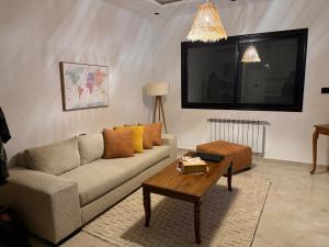 a living room with a couch and a coffee table at Nestlya Apartment in Sukrah