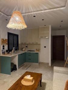 a kitchen with green cabinets and a table at Nestlya Apartment in Sukrah