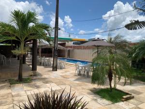 a resort with a pool and chairs and an umbrella at Sítio Resenha in Caucaia