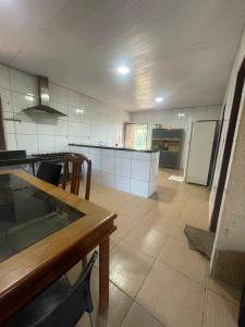 a large kitchen with a table and a counter top at Sítio Resenha in Caucaia