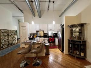 a large kitchen with a counter and a refrigerator at Stylish Loft, Walk to WORLD CUP! in Atlanta