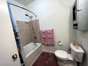 a bathroom with a tub and a toilet and a sink at Stylish Loft, Walk to WORLD CUP! in Atlanta +18 photos
