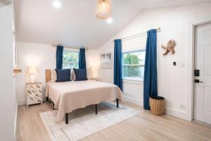 a bedroom with a bed with blue curtains and a window at The Margaret Suite in Key West