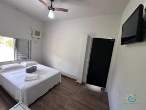 a bedroom with a bed and a flat screen tv at Pousada Chácara Sonho in Hortolândia