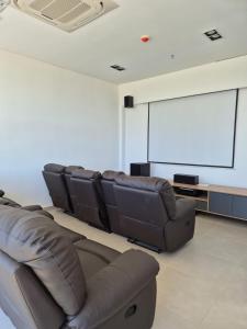 a living room with leather chairs and a projection screen at Molas 112B in Asunción