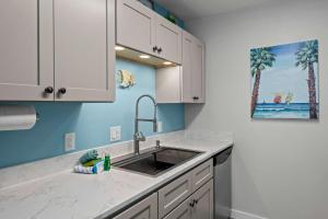a kitchen with white cabinets and a sink at Bikini Bottom Destin Harbor Private Gated Beach in Destin