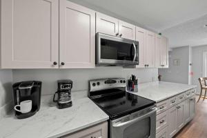 a white kitchen with a stove and a microwave at Bikini Bottom Destin Harbor Private Gated Beach in Destin +46 photos