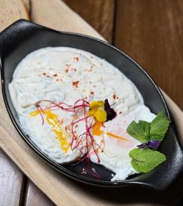 a cake with white frosting in a pan on a table at Hotel Victor in Prague +32 photos
