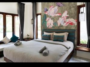 a bedroom with two beds and a painting on the wall at Navela in Ko Lanta