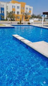 a large blue swimming pool in front of some buildings at DePA DRAGON in Tizayuca