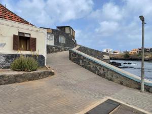 a walkway next to a building next to a river at Porto Calheta in Calheta