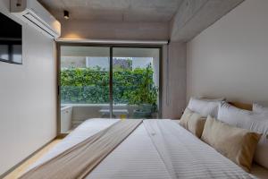a large bed in a room with a large window at Lulu Condesa by Capitalia in Mexico City