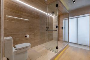 a bathroom with a toilet and a glass shower at Lulu Condesa by Capitalia in Mexico City +24 photos