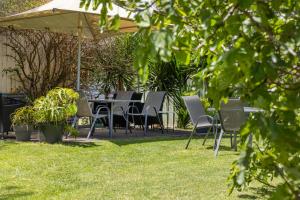 a group of chairs and tables under an umbrella at Pet Room at Moody's in Blairgowrie