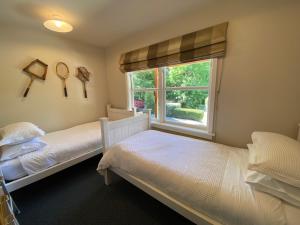 two twin beds in a bedroom with a window at Omarama township location - how good! in Omarama