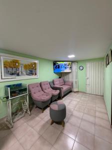 a living room with a couch and a tv at Aquarium Rooms in Floridablanca