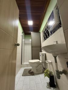 a bathroom with a toilet and a sink and a shower at Aquarium Rooms in Floridablanca