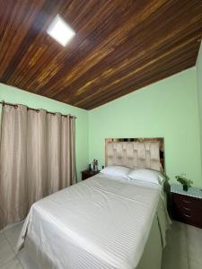 a bedroom with a white bed with a wooden ceiling at Aquarium Rooms in Floridablanca