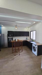 a large kitchen with a table and a microwave at Ouakam Monument de la Renaissance 2 in Dakar