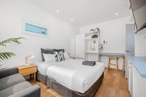a white bedroom with a bed and a couch at Pet Room at Moody's in Blairgowrie