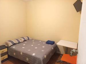a small bedroom with a bed and a desk at La Posada in Cajamarca