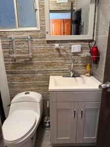 a bathroom with a toilet and a sink and a mirror at Comfort House in Manuel F. Martínez +48 photos