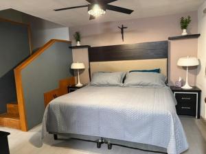 a bedroom with a large white bed with two lamps at Comfort House in Manuel F. Martínez