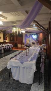 a long table with white table cloths on it at Kuna Hotel in Cuenca